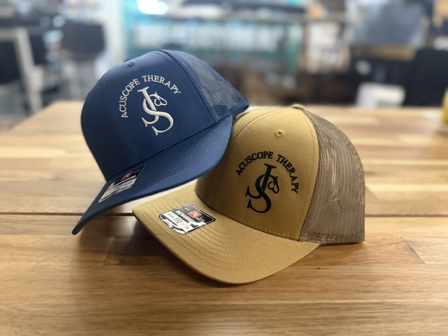 Richardson trucker hats in navy and khaki with embroidered Acuscope Therapy monogram logo